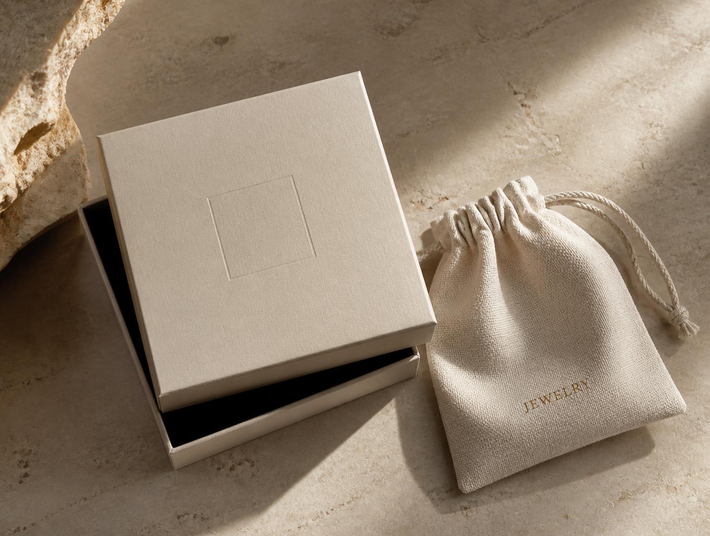 Scatola color limestone con interno scuro e sacchetto in tessuto naturale